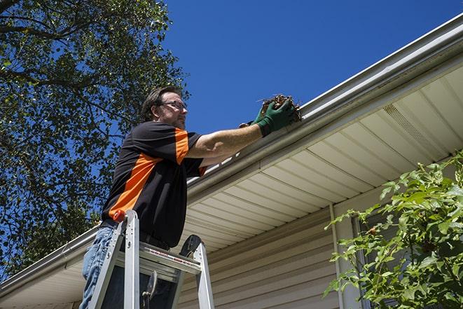 man working on gutter maintenance with tools in Grover Beach